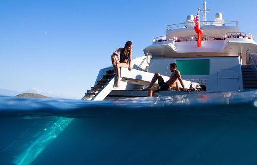 charter guests relax on the swim platform of charter yacht AXIOMA 