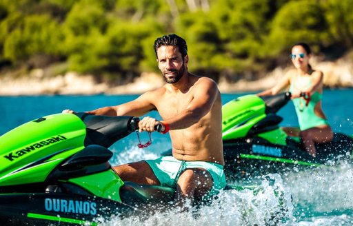 A couple ride on JetSkis onboard MY Ouranos