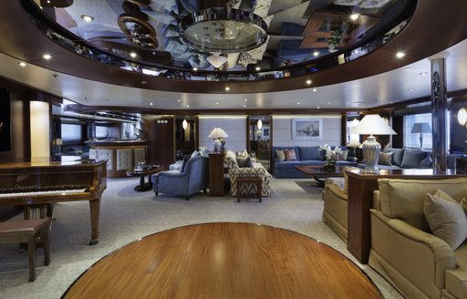 spacious main salon with grand piano and seating on board charter yacht ‘Lauren L’ 