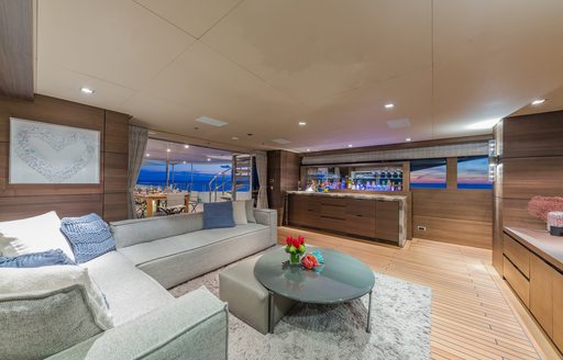 Skylounge salon on charter yacht Big Sky, with marble bar and sunset views in background