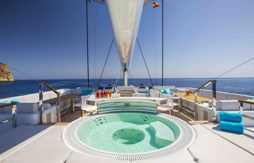 Jacuzzi with swim-up bar and sunpads on sundeck of luxury yacht AQUIJO 