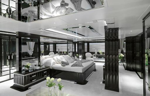 Overview of a guest cabin onboard charter yacht SILVER ANGEL, central berth facing starboard with black and white decor 