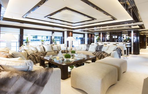 Interiors onboard charter yacht ILLUSION V, spacious lounge with plush cream seating 