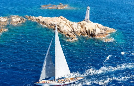 Aerial shot of sailing yacht rounding corner of La Maddalena archipelago in Porto Cervo during Loro Piana Superyacht Regatta