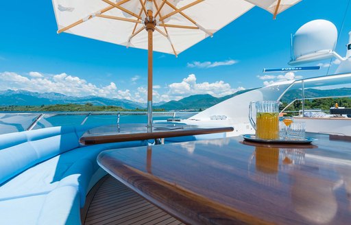 Sundeck on luxury yacht Duke Town, with parasols shading alfresco dining area