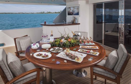 circular table set for dinner on aft deck of luxury yacht AMITIÉ 