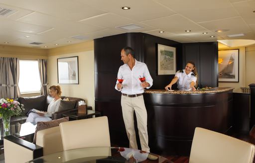 charter guests enjoy cocktails in sky lounge of luxury yacht L’Albatros