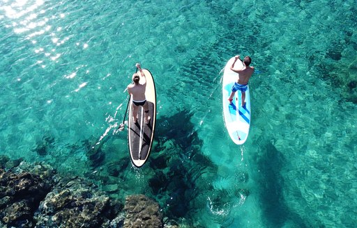 two people paddle boarding in Greece