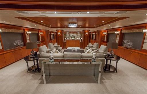 sofas and rich wooden panels in main salon of charter yacht skyfalll