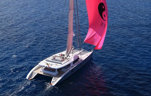 catamaran che's pink spinnaker with ying and yang symbol