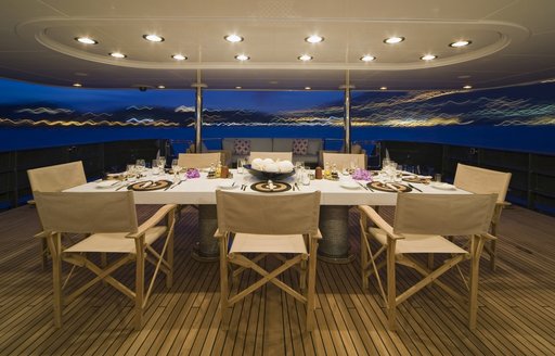 al fresco dining area on the aft deck of charter yacht CYAN at night