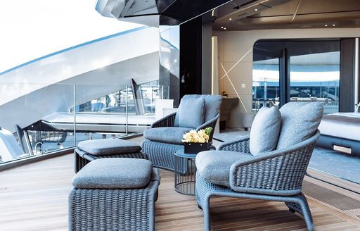 Exterior seating area of boat charter THIS IS IT, pair of fray chairs and matching foot rests