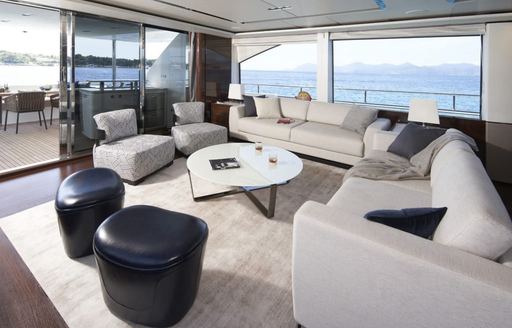 Main salon lounge onboard charter yacht ANKA, plush cream seating with large windows aft