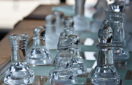 a set of clear glass chess pieces that guests can play while they enjoy their alone time on their luxury charter while also social distancing from high risk  spaces 