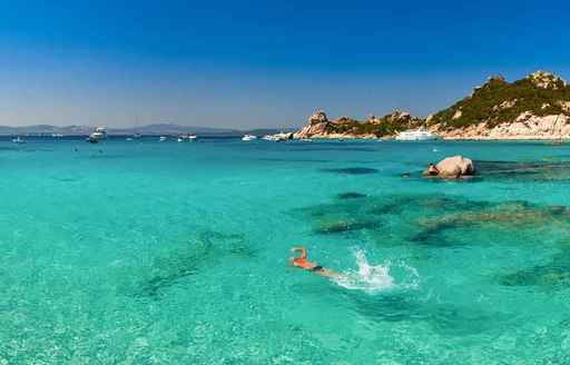 Man swims in crystal clear water in costa smeralda