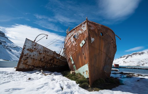 Wreck of two boats lie in ice and snow in Antarctica