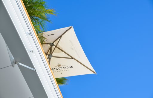 An umbrella advertising Moet et Chandon on a roof terrace against a blue sky
