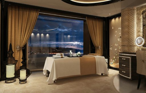 Massage room onboard charter yacht KISMET, center treatment table adjacent to large full height window