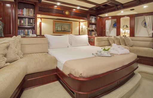 Large bed and cream seating in master suite of charter yacht Gloria