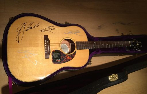 only signed guitar in the world donated by rock band kings of leon to auction for cogs for cancer charity