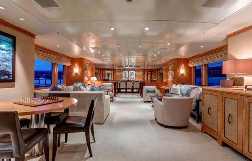 Main salon onboard charter yacht HELIOS 2, with spacious lounge area aft and a games table in the foreground
