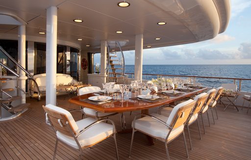 rectangular alfresco dining table on main aft deck of superyacht SUNRISE