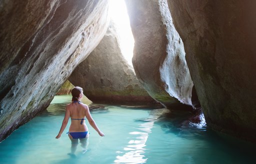A women wading in turquoise waters at The Baths on Virgin Gorda in the BVIs, Caribbean