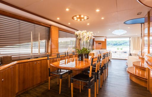 Formal dining area onboard charter yacht Winning Streak 2, long table surrounded by chairs with open exit to the exterior in the background