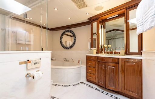 Bathroom attached to the master cabin onboard superyacht charter REMEMBER WHEN, with a shower cubicle in the foreground and a bath tub aft