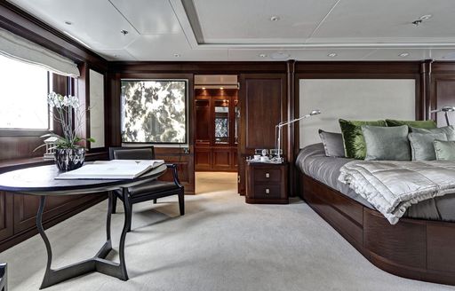 bed and desk area in main salon of luxury yacht Azteca II 