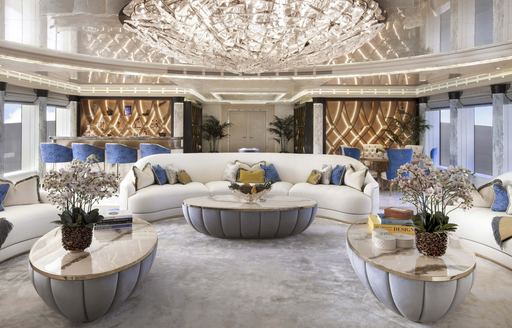 Interior lounge area onboard charter yacht AHPO, plush seating arranged in a U shape with a central coffee table