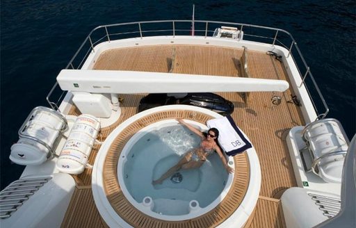 charter guests relaxes in the Jacuzzi on the sundeck of luxury yacht Deep Blue II