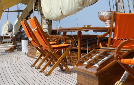 chairs and table set up for alfresco dining on deck of sailing yacht PURITAN
