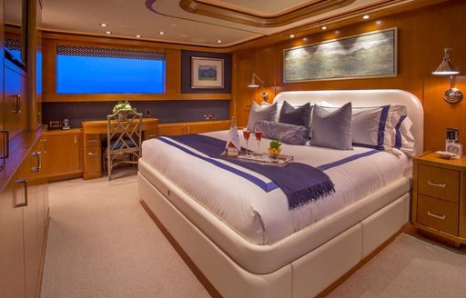 master suite with rich woods and pale furnishings on board luxury yacht Far Niente