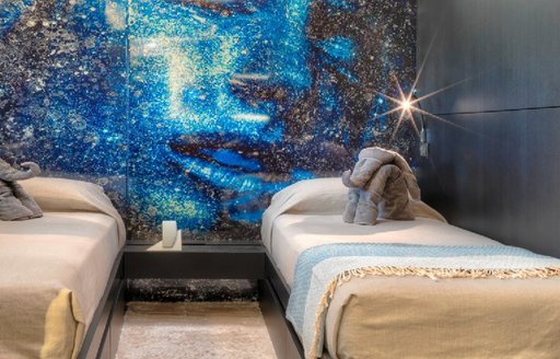 outer space wall art in children's cabin on board motor yacht giraud, with plush elephant toys on twin beds