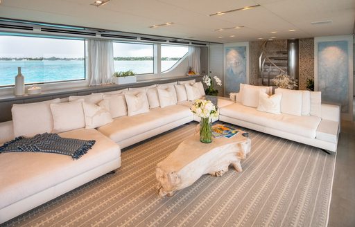 Interior lounge area onboard charter yacht HALCYON, with large white sofas and a coffee table.