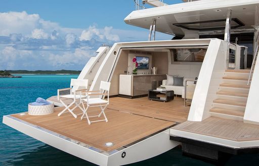 Overview of the transom beach club onboard charter yacht ENTREPRENEUR, with directors chairs on the deck.