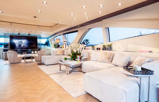 Interior lounge area onboard boat charter MRS GREY with plush cream seating and large windows