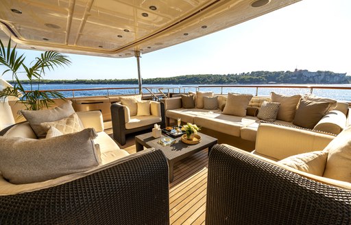 Exterior deck space onboard charter yacht BEHIKE, wicker sofas with panoramic views