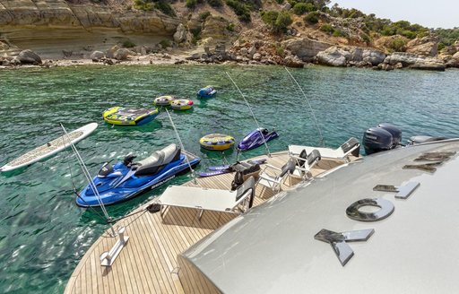 sun loungers line up on swim platform of superyacht ‘My Toy’ with water toys nearby in water