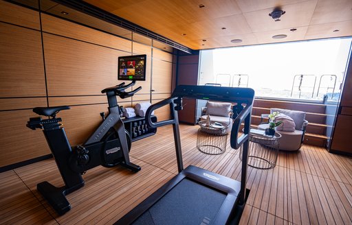 Overview of the gym onboard charter yacht RELIANCE, with open transom door in background