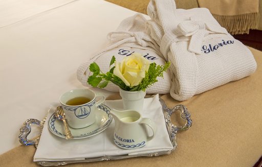 tray of tea and dressing gowns arranged on bed on board charter yacht Gloria