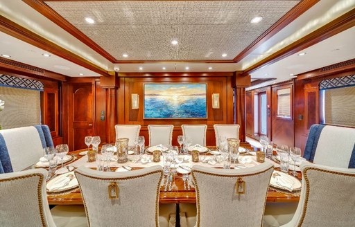 Formal dining area onboard charter yacht VALHALLA, central dining table with ornate decoration and ten seats.