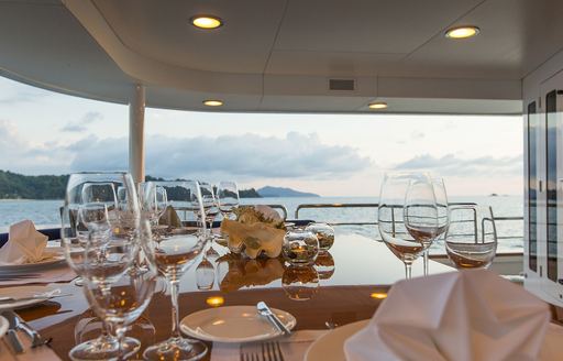 al fresco dining set up with close shot of wine glasses on luxury yacht northern sun 
