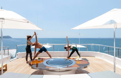 charter guests on board motor yacht Lady E doing yoga