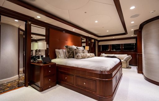 Master cabin onboard charter yacht ZEXPLORER, central berth facing starboard with a sofa in the background