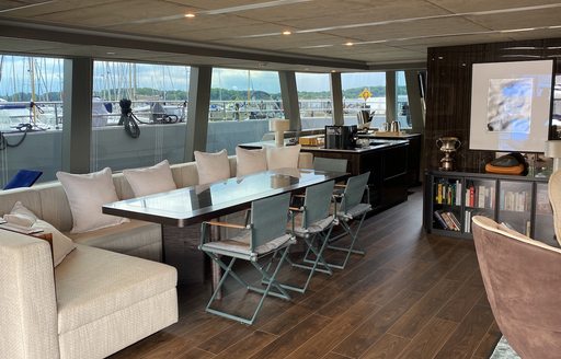 Dining area onboard S/Y GREY B with large windows surrounding 