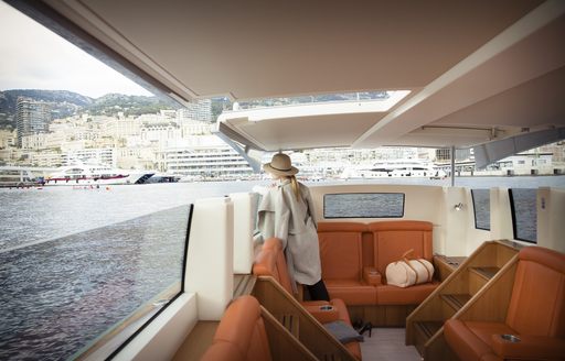 Charter guest on superyacht looks out over Monaco from on board limo tender