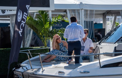 Visitors to FLIBS relaxing on the bow of a motor yacht.