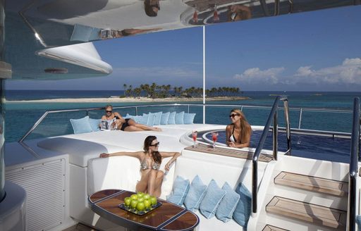 guests relax in the spa pool and surrounding lounging areas on board motor yacht Lady E